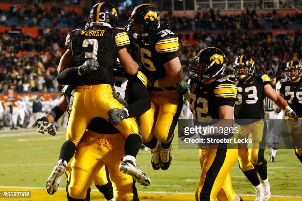 Brandon Wegher of the Iowa Hawkeyes celebrates with his teammates after he scored a 32-yard rushing touchdown late in the fourth quarter against the...