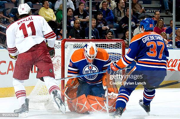 Martin Hanzal of the Phoenix Coyotes skates past Jeff Deslauriers of the Edmonton Oilers and Denis Grebeshkov of the Edmonton Oilers as the Phoenix...