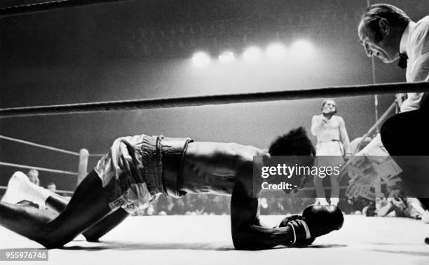 French middleweight boxer Jean-Claude Bouttier looks at Jamaican-born British middleweight boxer Bunny Sterling laying on the ring during the...