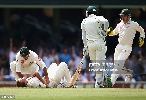 Ricky Ponting and Brad Haddin of Australia rush to the aid of an injured Nathan Hauritz of Australia after he took the wicket of Mohammad Yousuf of...