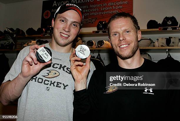 Matt Beleskey and Saku Koivu the Anaheim Ducks pose for a photo with their pucks for the first NHL career goal and 200th goal, respectively, against...