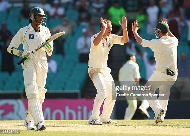 Nathan Hauritz of Australia celebrates with team mate Phillip Hughes after taking the final wicket of Umar Gul of Pakistan during day four of the...