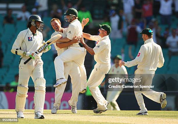 Nathan Hauritz of Australia celebrates with team mates after taking the final wicket of Umar Gul of Pakistan to win the test match during day four of...