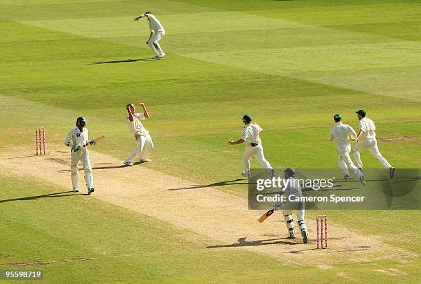 Nathan Hauritz of Australia celebrates with team mates after taking the final wicket of Umar Gul of Pakistan to win the test match during day four of...