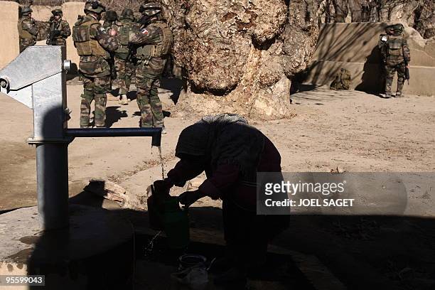 Young girl collects water as French soldiers of the 13 BCA patrol at Jalokhel in Kapisa province on January 5, 2010. About 113,000 US and allied...