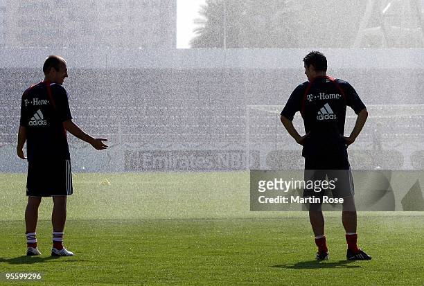 Arjen Robben and Mark van Bommel of Bayern Muenchen take a refreshment during the FC Bayern Muenchen training session at the Al Nasr training ground...