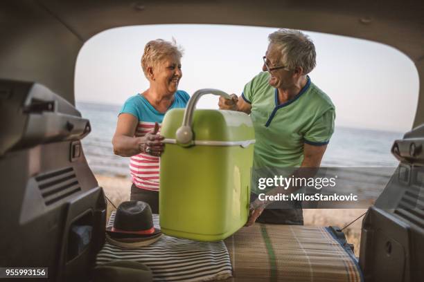 senior couple packing a car trunk - broken refrigerator stock pictures, royalty-free photos & images
