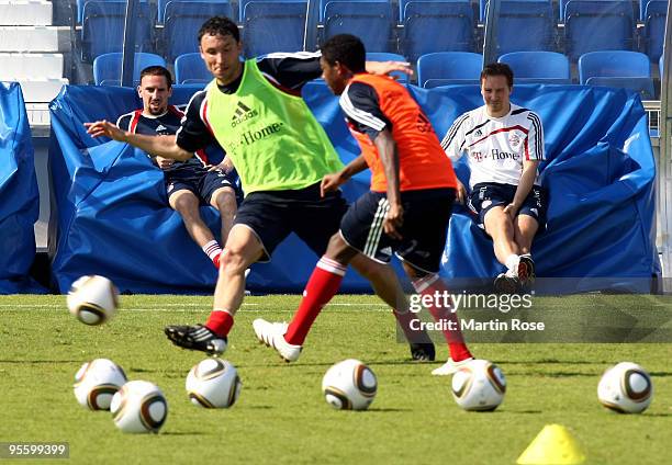 Franck Ribery of Bayern Muenchen watches Mark van Bommel und David Abala during the FC Bayern Muenchen training session at the Al Nasr training...
