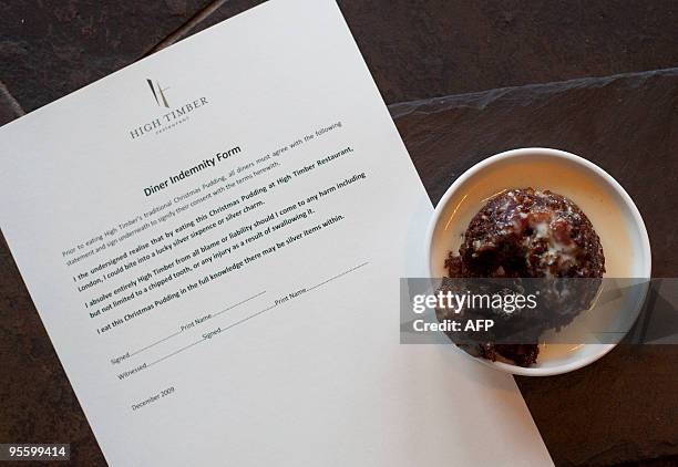 Christmas pudding that contains a silver lucky charm is pictured next to disclaimer form at the High Timber restaurant in London. Neleen Strauss, the...
