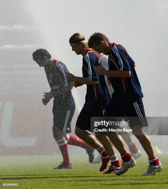 Danijel Pranjic, Anatoliy Tymoshchuk and Ivica Olic of Bayern Muenchen take a refreshment during the FC Bayern Muenchen training session at the Al...