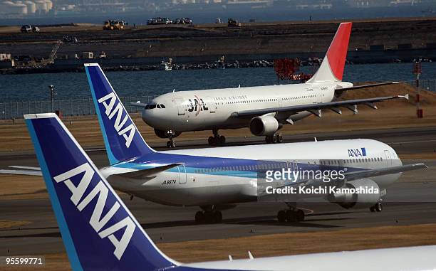 Japan Airlines and All Nippon Airways passenger planes sit on the tarmac of Tokyo International Airport on January 6, 2010 in Tokyo, Japan. Asia's...