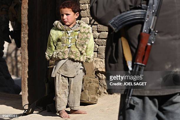 An Afghan girl watches as French soldiers with members of the Afghan National Police conduct a house-to-house search in Jalokhel in Kapisa province...