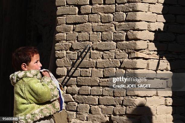 An Afghan girl watches as French soldiers with members of the Afghan National Police conduct a house-to-house search in Jalokhel in Kapisa province...