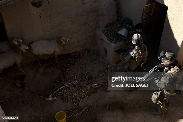 French soldiers with unseen members of the Afghan National Police conduct a house-to-house search in Jalokhel in Kapisa province on January 5, 2010....