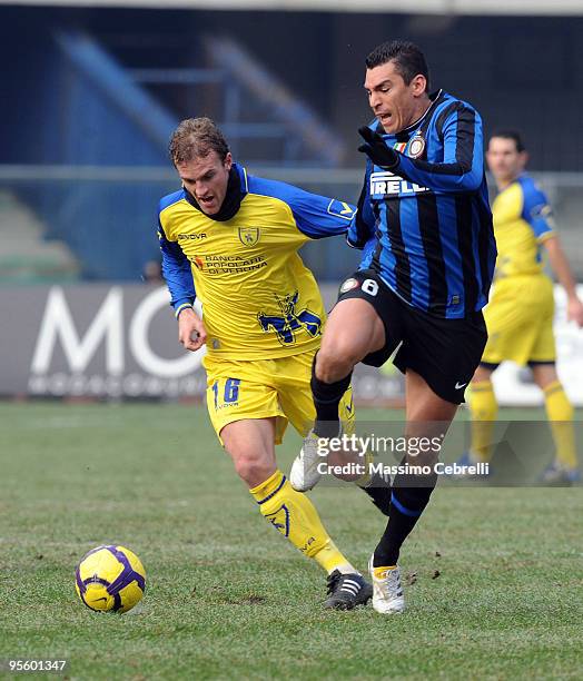 Luca Rigoni of AC Chievo Verona battles for the ball against Lucio of FC Inter Milan during the Serie A match between AC Chievo Verona and FC Inter...