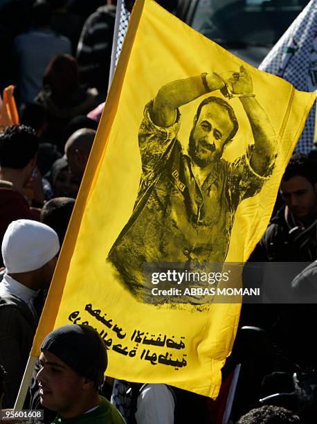 Palestinians hold up a portrait of imprisoned Palestinian leader Marwan Barghuti during a rally marking the anniversary of the founding of the...