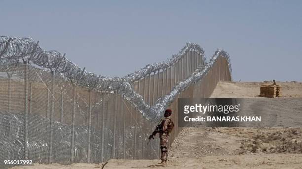 Pakistani army soldier stands guard along with border fence at the Pak-Afghan border near the Punjpai area of Quetta in Balochistan on May 8, 2018. -...