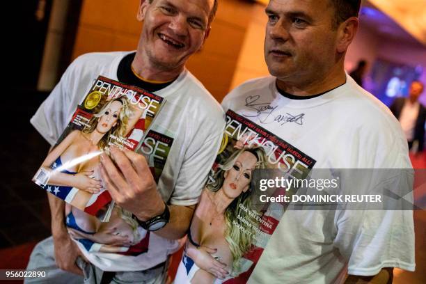 Fans of adult film star Stephanie Clifford, AKA Stormy Daniels, shows off their signed shirts and magazine outside the Penthouse Club in...