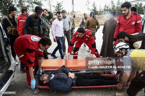 Paramedics transport an injured Syrian into an ambulance from a gurney upon arriving at Abu al-Zandin checkpoint near al-Bab in northern Syria on May...