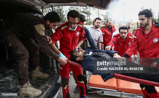 Paramedics transport an injured Syrian into an ambulance from a gurney upon arriving at Abu al-Zandin checkpoint near al-Bab in northern Syria on May...