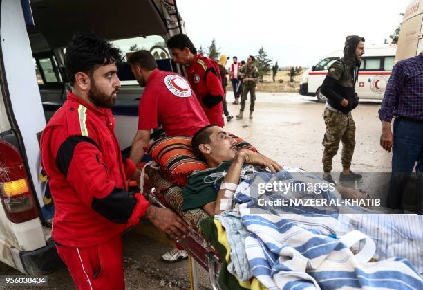 Paramedics transport an injured Syrian into an ambulance from a gurney upon arriving at Abu al-Zandin checkpoint near al-Bab in northern Syria on May...