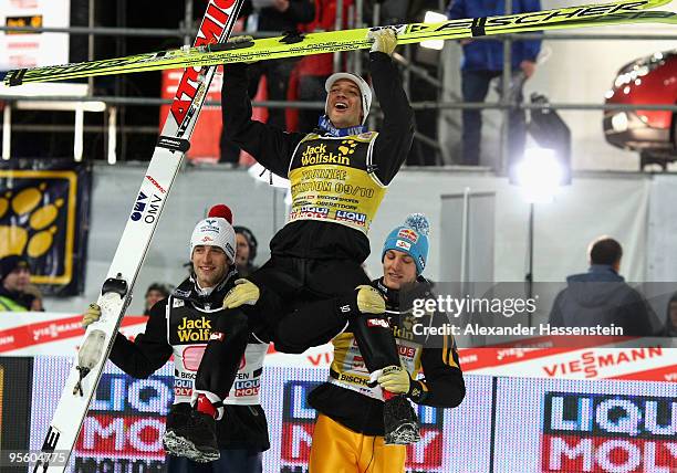 Andreas Kofler of Austria celebrates winning the 58th Four Hills ski jumping tournament with his team mates Wolfgang Loitzl and Gregor Schlierenzauer...