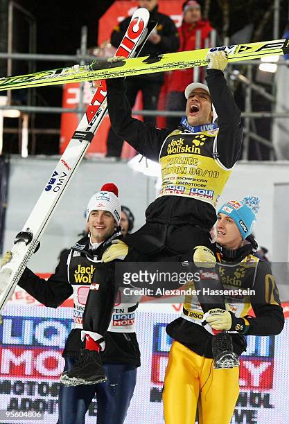 Andreas Kofler of Austria celebrates winning the 58th Four Hills ski jumping tournament with his team mates Wolfgang Loitzl and Gregor Schlierenzauer...