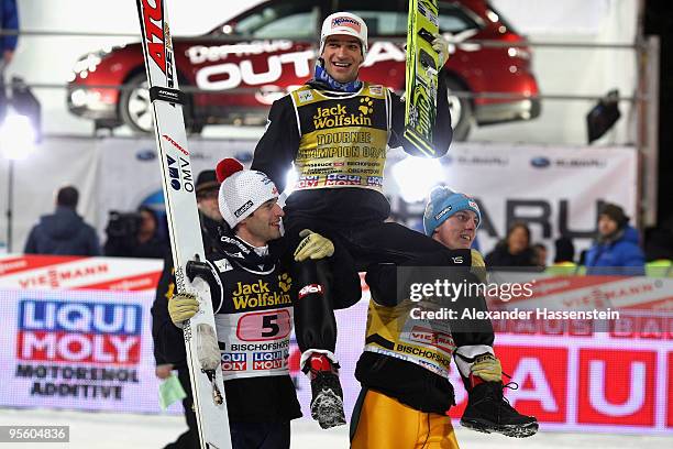 Andreas Kofler of Austria celebrates winning the 58th Four Hills ski jumping tournament with his team mates Wolfgang Loitzl and Gregor Schlierenzauer...