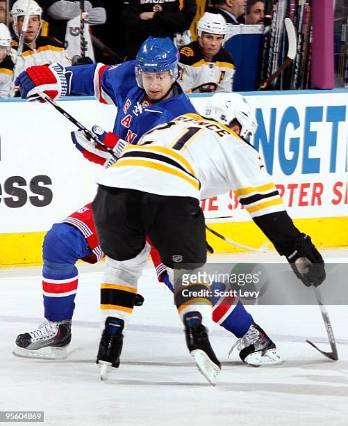 Artem Anisimov of the New York Rangers skates for the puck against Andrew Ference of the Boston Bruins on January 4, 2010 at Madison Square Garden in...