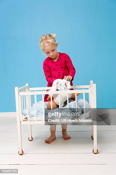 girl playing with a doll sweden. - doll house stockfoto's en -beelden