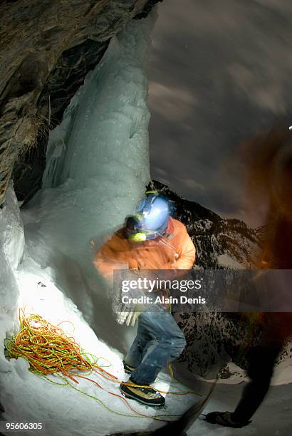 a young man prepares for ice climbing at night with a headlamp near ouray, colorado. - ouray colorado bildbanksfoton och bilder