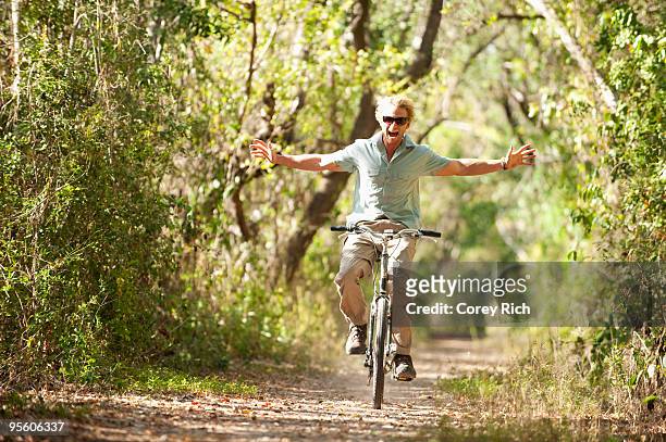 a man rides a bicycle with - hands free cycling - fotografias e filmes do acervo