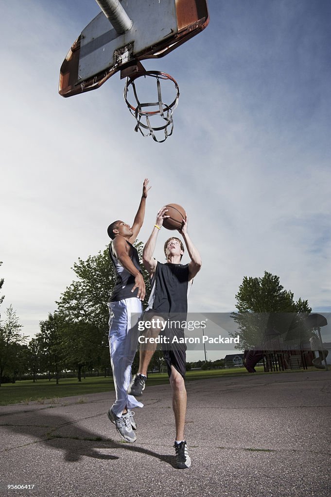 Two young men play one on one Basketball at Barstow Park in Vermillion, South Dakota (lit with flash