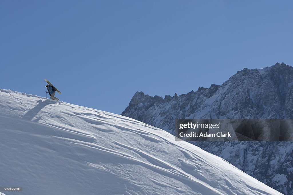 A female skier hiking with skis in Chile.