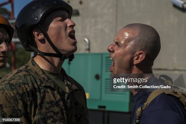 Marine Corps Drill Instructor Staff Sgt Michael Stricklin with Mike Company, 3rd Recruit Training Battalion, corrects a recruit after completing the...