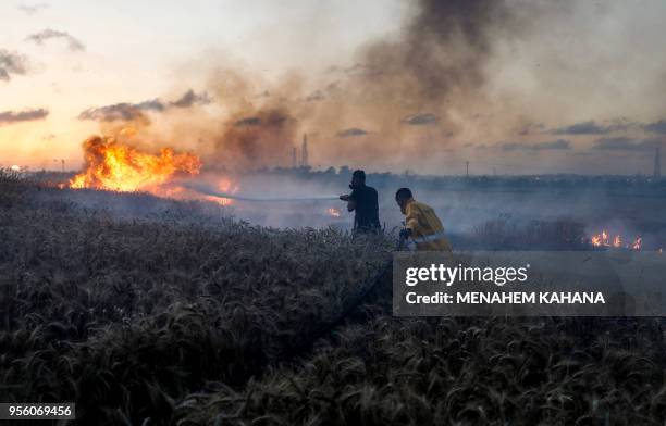 Israeli firefighters attempt to extinguish a fire in a wheat field near the Kibbutz of Nahal Oz, along the border with the Gaza strip, on May 8, 2018...