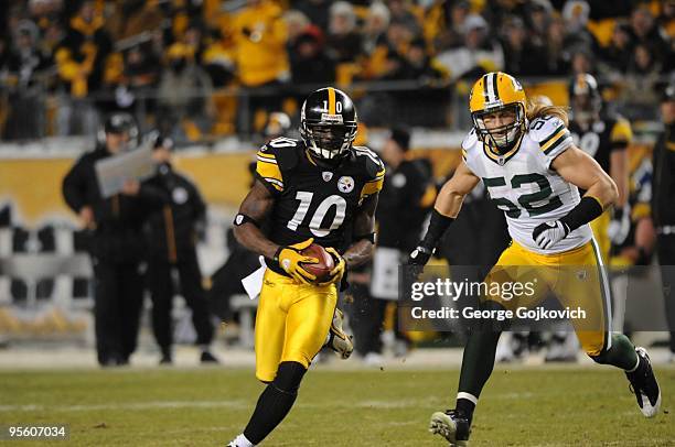 Wide receiver Santonio Holmes of the Pittsburgh Steelers is pursued by linebacker Clay Matthews of the Green Bay Packers during a game at Heinz Field...