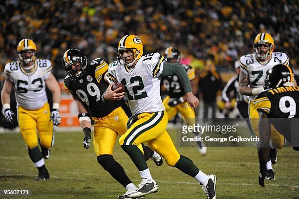 Quarterback Aaron Rodgers of the Green Bay Packers is chased by defensive lineman Brett Keisel of the Pittsburgh Steelers as he runs with the...