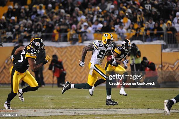 Wide receiver Donald Driver of the Green Bay Packers is pursued by defensive backs Ryan Clark and Ike Taylor of the Pittsburgh Steelers after...