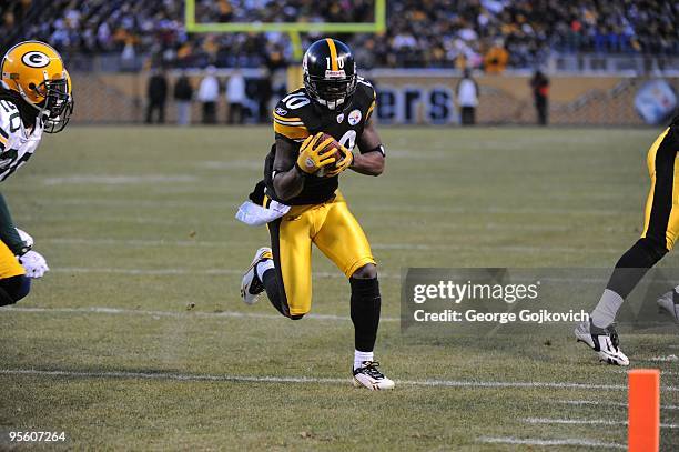 Wide receiver Santonio Holmes of the Pittsburgh Steelers runs with the football after catching a pass against the Green Bay Packers during a game at...