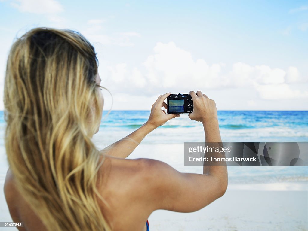 Young female taking photo with digital camera