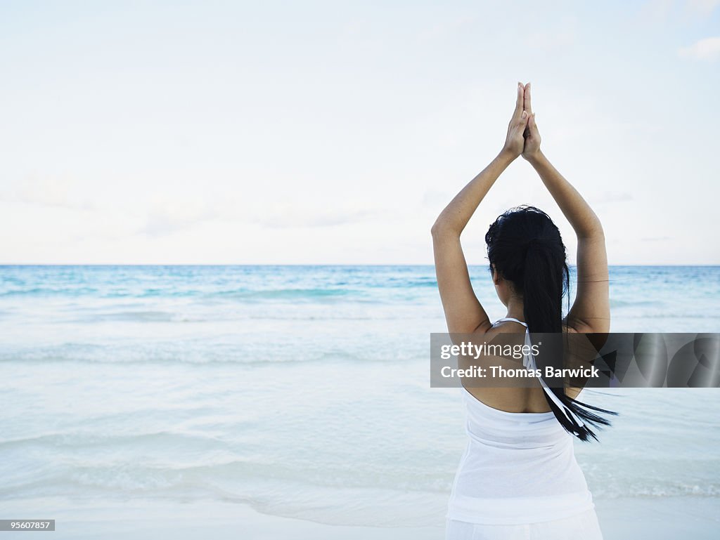 Woman practicing yoga looking out over Caribbean