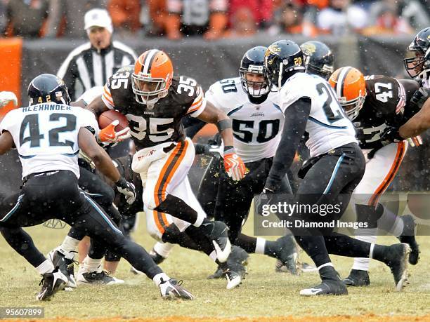 Running back Jerome Harrison of the Cleveland Browns carries the ball as defensive backs Gerald Alexander and Anthony Smith and linebacker Russell...