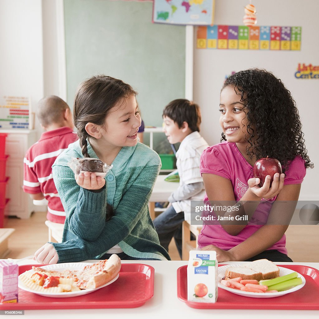 Young girls comparing school lunches