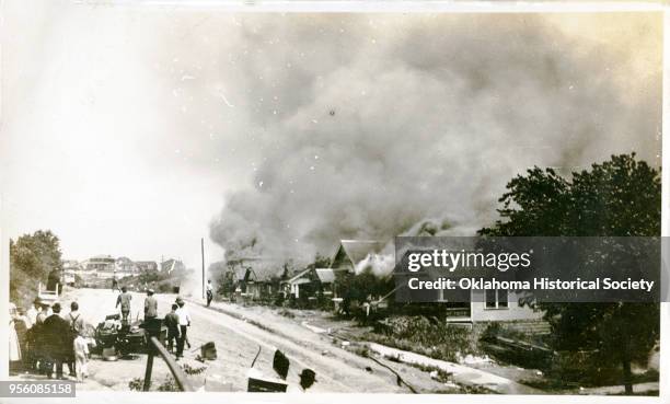 Group of people looking at smoke in the distance coming from damaged properties following the Tulsa Race Massacre, Tulsa, Oklahoma, June 1921.