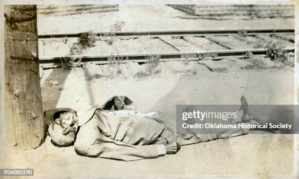 Man on the ground beside train tracks following the Tulsa Race Massacre, Tulsa, Oklahoma, June 1921.