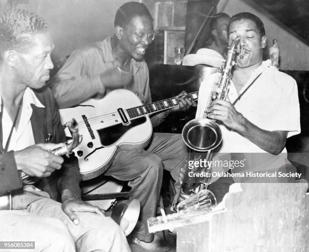 Photograph of, left to right, Sam Hughes, Charlie Christian, Leslie Sheffield and Dick Wilson having a music jam session at Ruby's Grill, Oklahoma...
