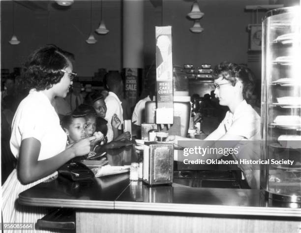 Photograph of Barbara Posey, Linda Pogue, Arnetta Carmichael, and other unidentified people at a Civil Rights sit-in protesting segregation at John A...