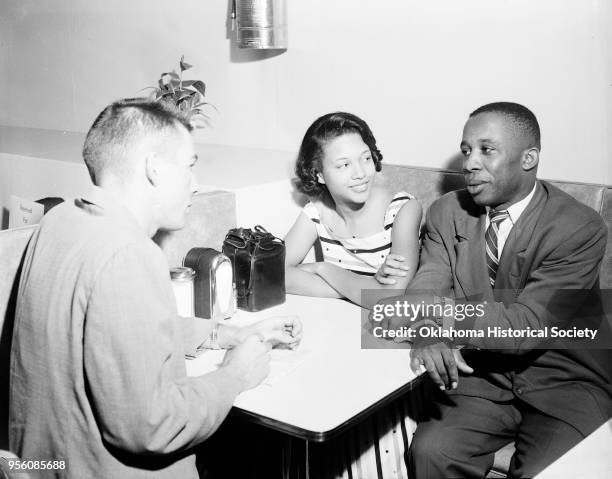 Photograph of Barbara Posey and John B White talking to a Daily Oklahoman reporter during a sit-in at John A Brown Company, Oklahoma City, Oklahoma,...