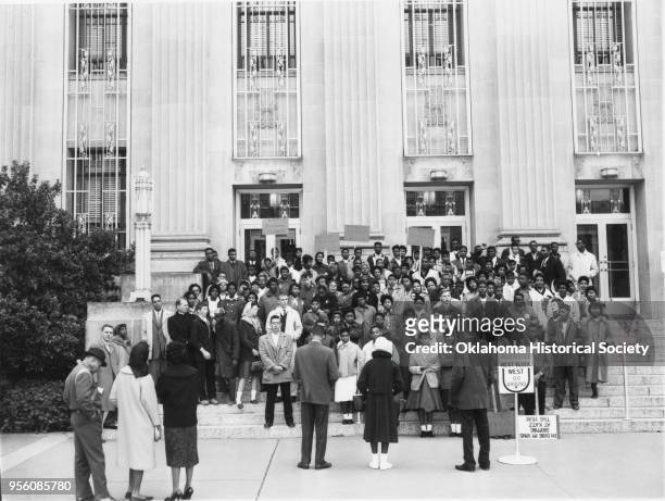 Photograph of a crowd of Civil Rights activists, mostly young adults, holding signs, gathered in front of the Municipal Building, Oklahoma City,...